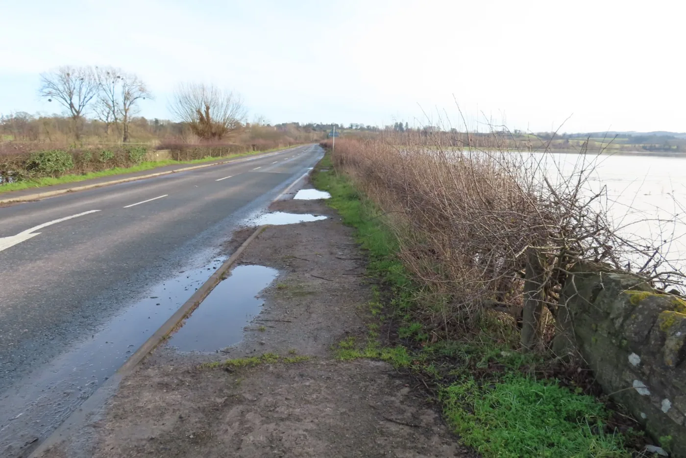 The A438 approaching Lugwardine in January 2025, with floodwater in the fields beside the road. The photo was taken before the scheme and does not show any of the planned works.